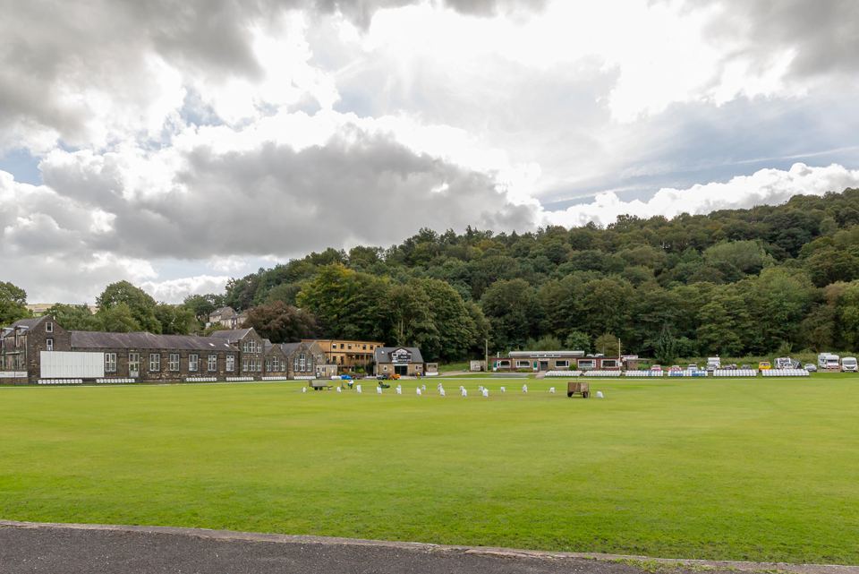 Cricket ground and wooded hillside