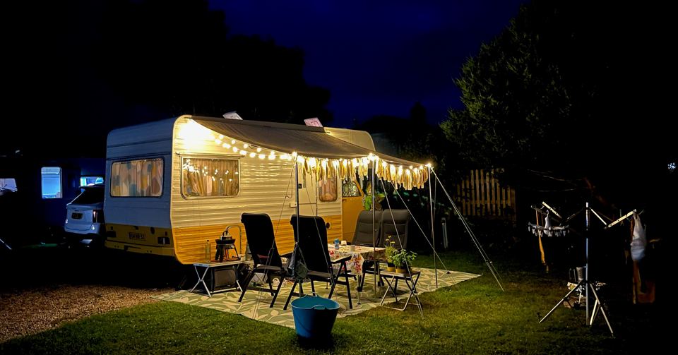 Caravan with string lights at night