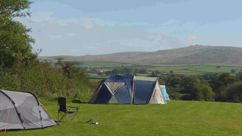 Tent pitched in the field with hills