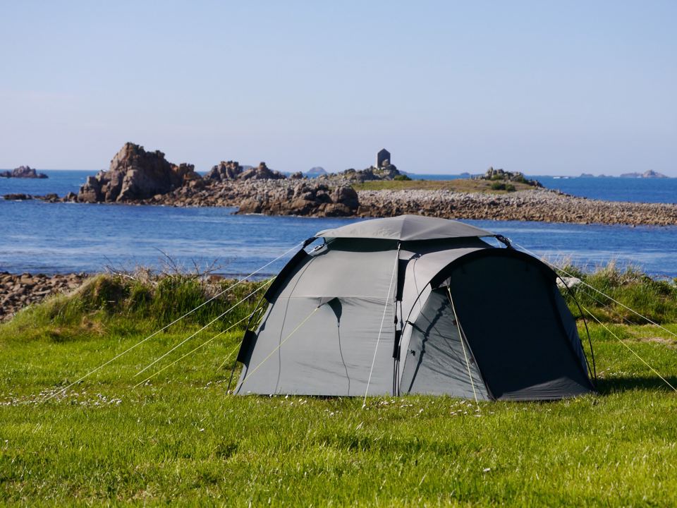 Tent on the grass above the rocks