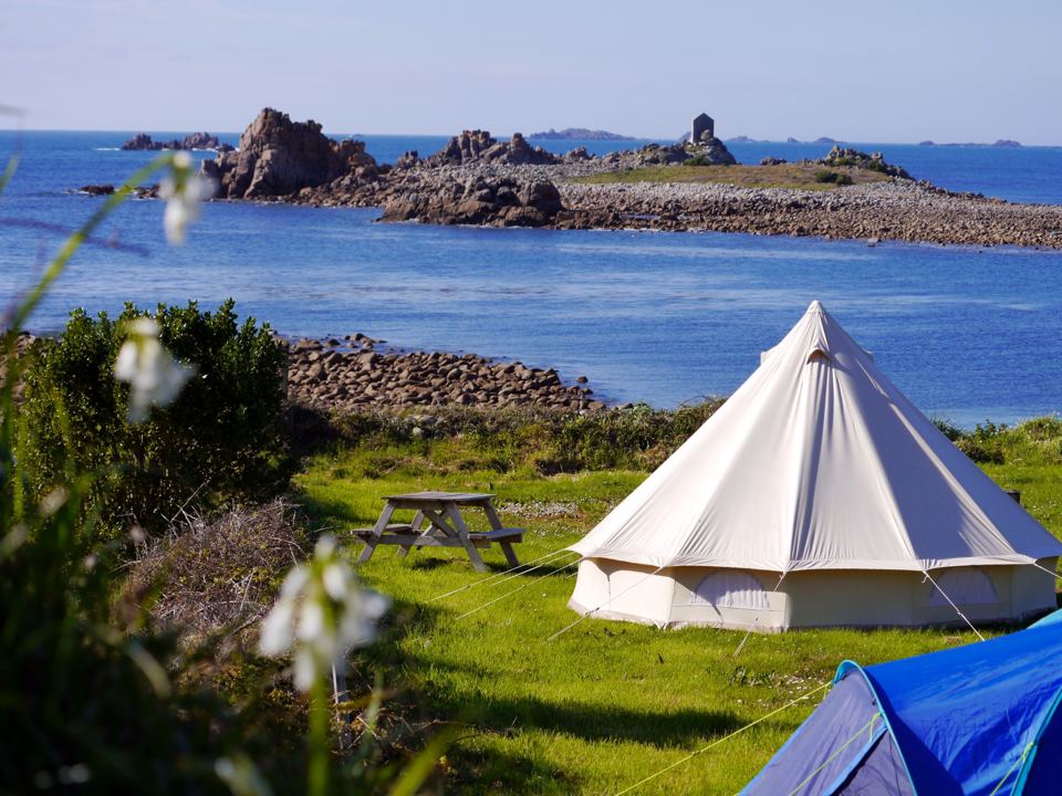 Bell tent by the rocks and sea