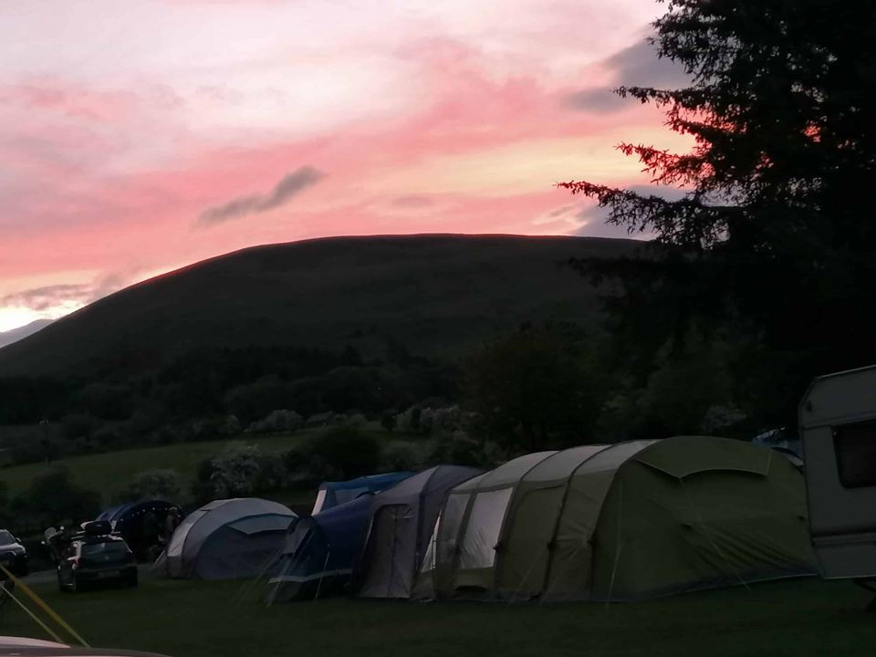Tents at sunset under the hills