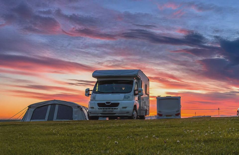 Motorhome and tent at sunset
