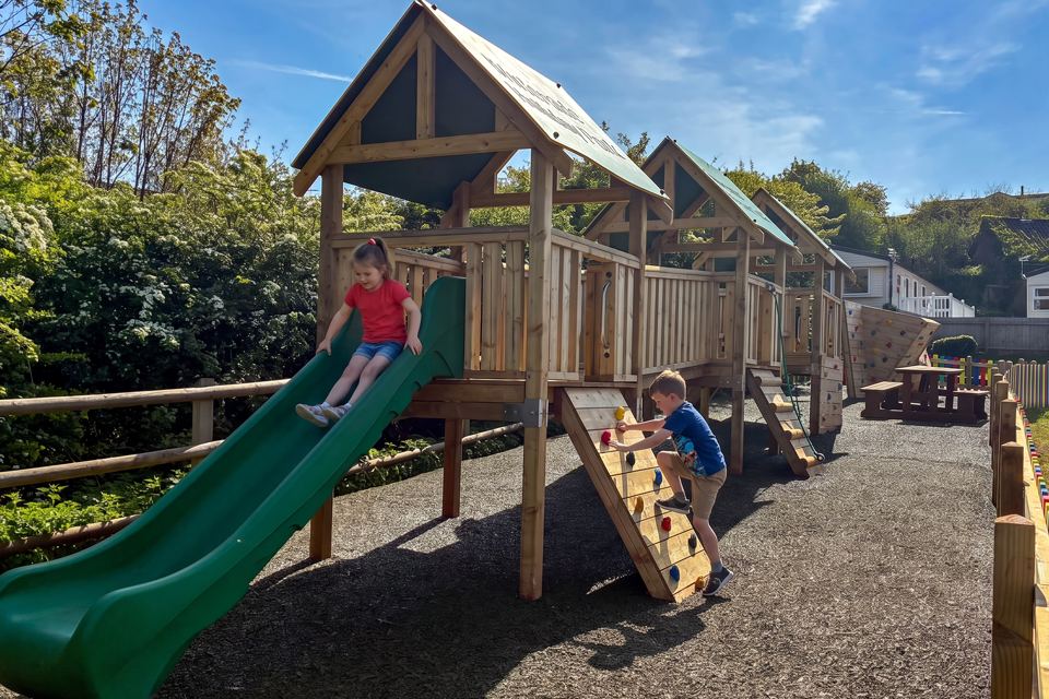 Play area with slide and climbing frame