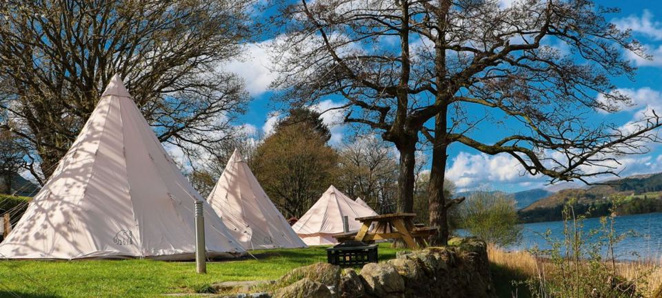 Tipis on the lakeside grass