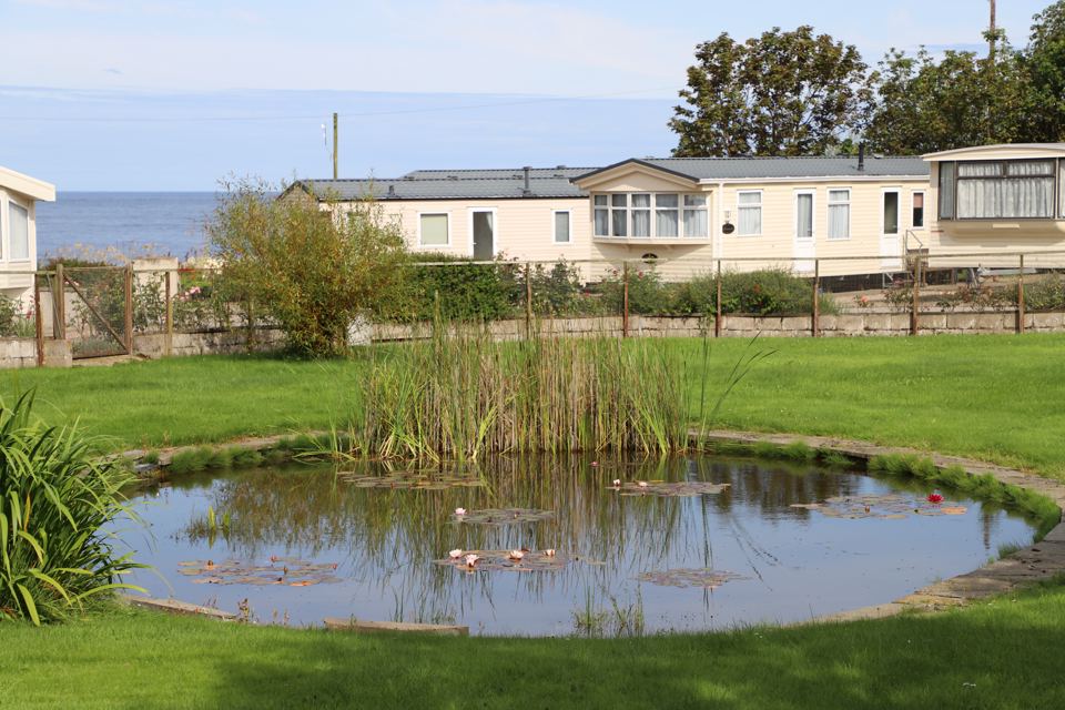 Pond and caravans by the sea