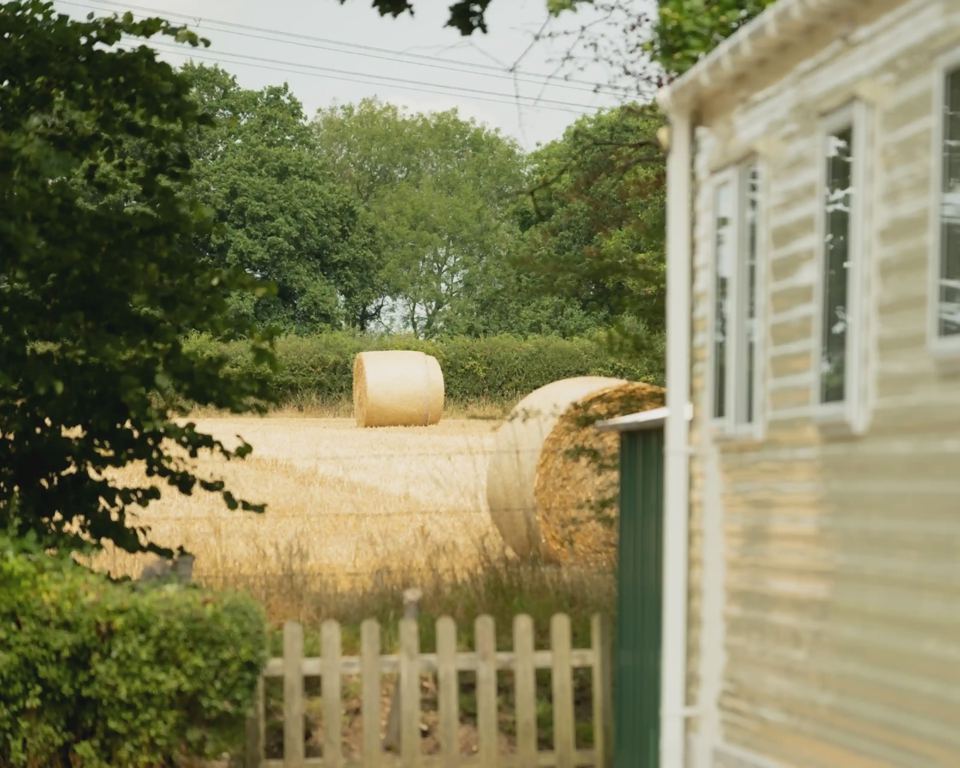 Caravan by a hay field