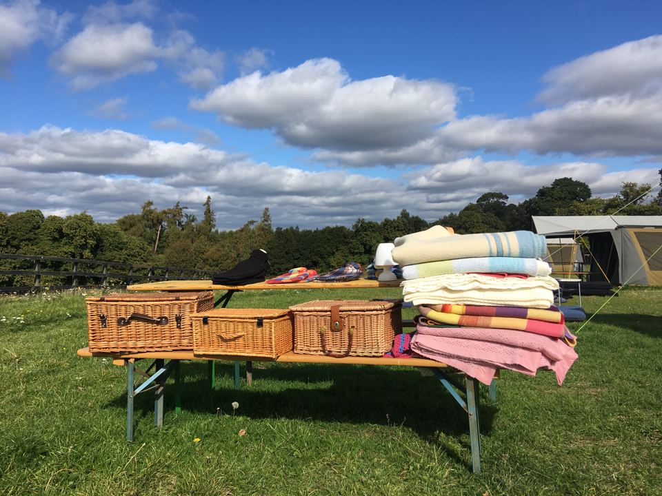 Picnic bench and blankets in the field