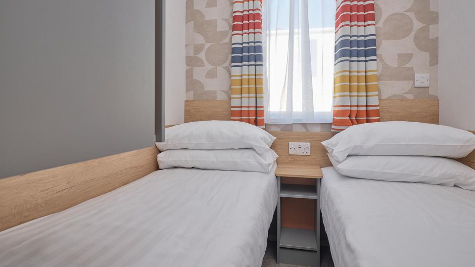 Twin bedroom with striped curtains