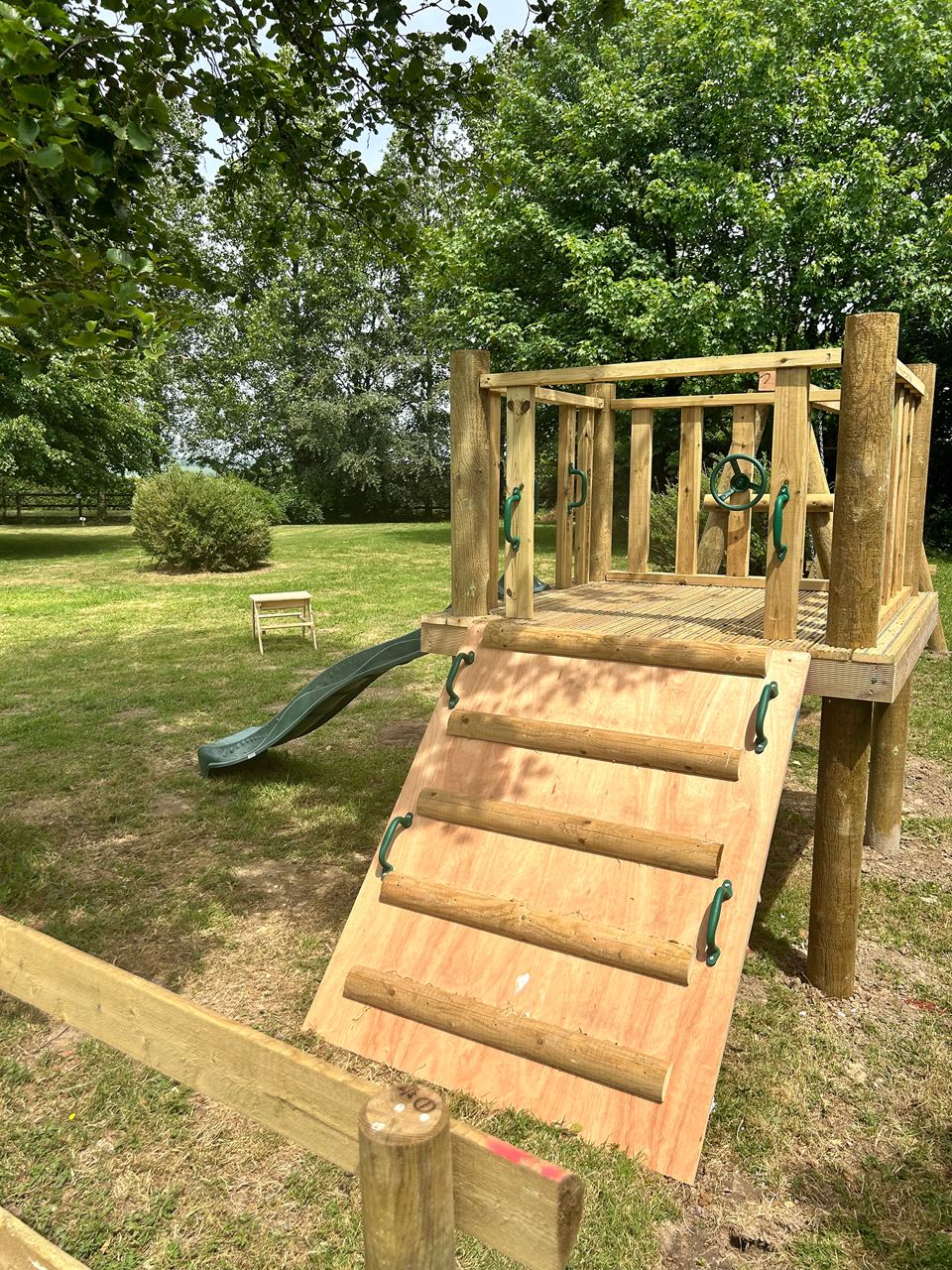 Wooden climbing frame and slide